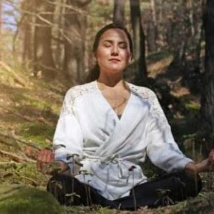 woman meditating in a forest
