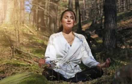 woman meditating in a forest