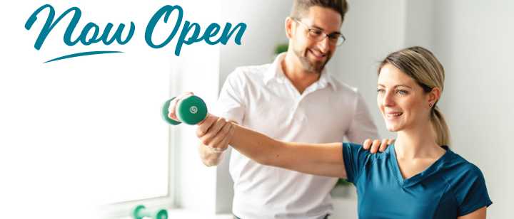 "Now Open" text and physical therapist helping patient do exercise with dumbbell 