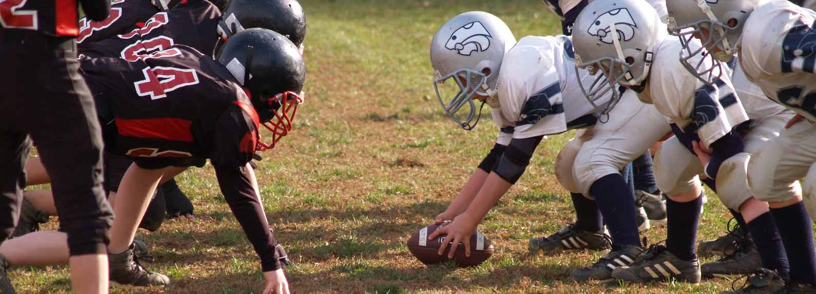 two youth football teams facing off at the line of scrimmage
