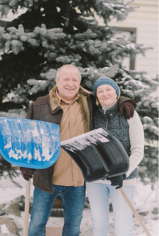 senior couple shoveling snow