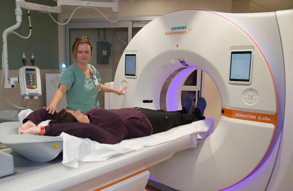 Diagnostic imaging tech with patient and CT scanner