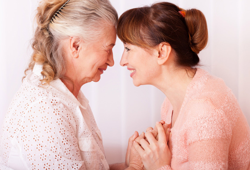 elderly mother and daughter holding hands