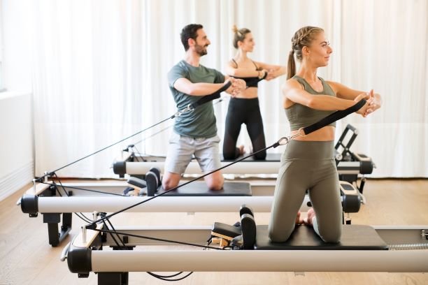 Group of people exercising on pilates reformer