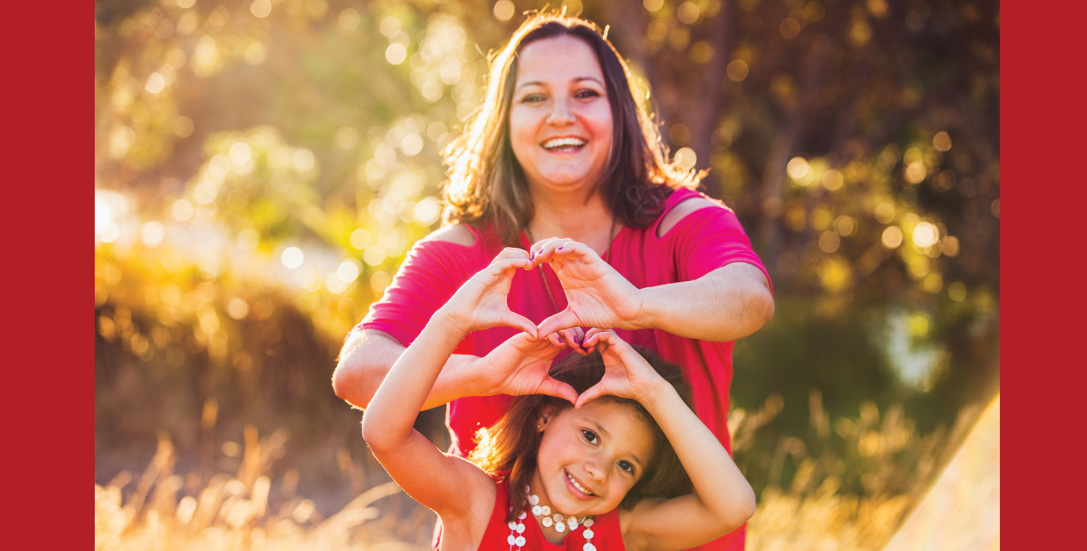 mother and daughter forming heart with hands