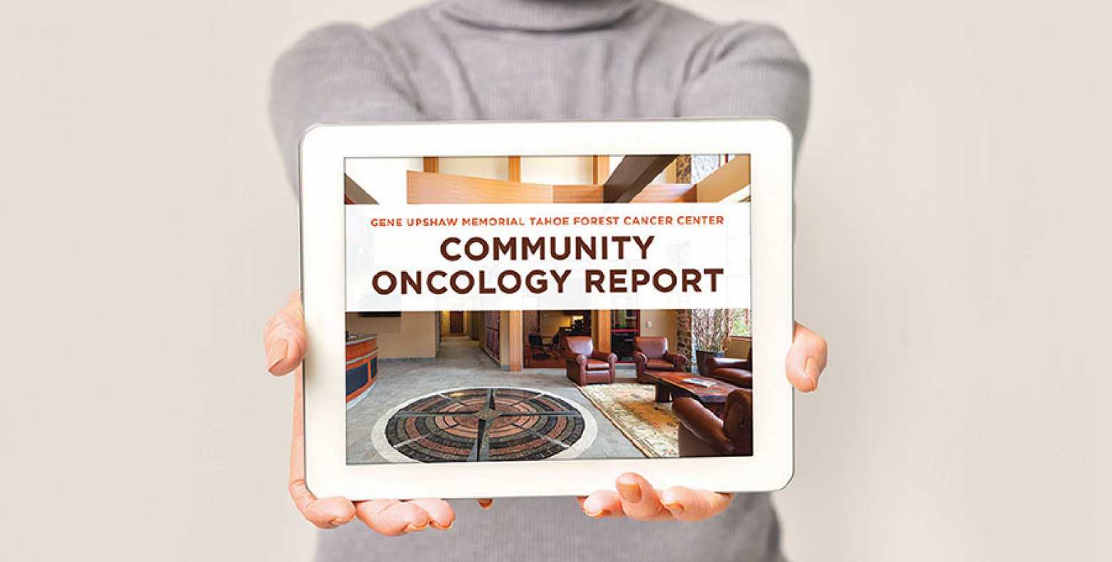 Woman holding ipad with Commmunity Oncology report cover on screen