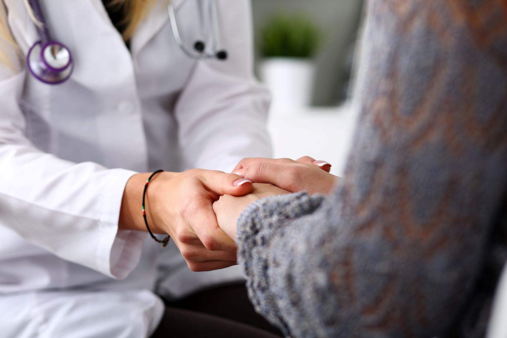 A doctor holds a patient's hands