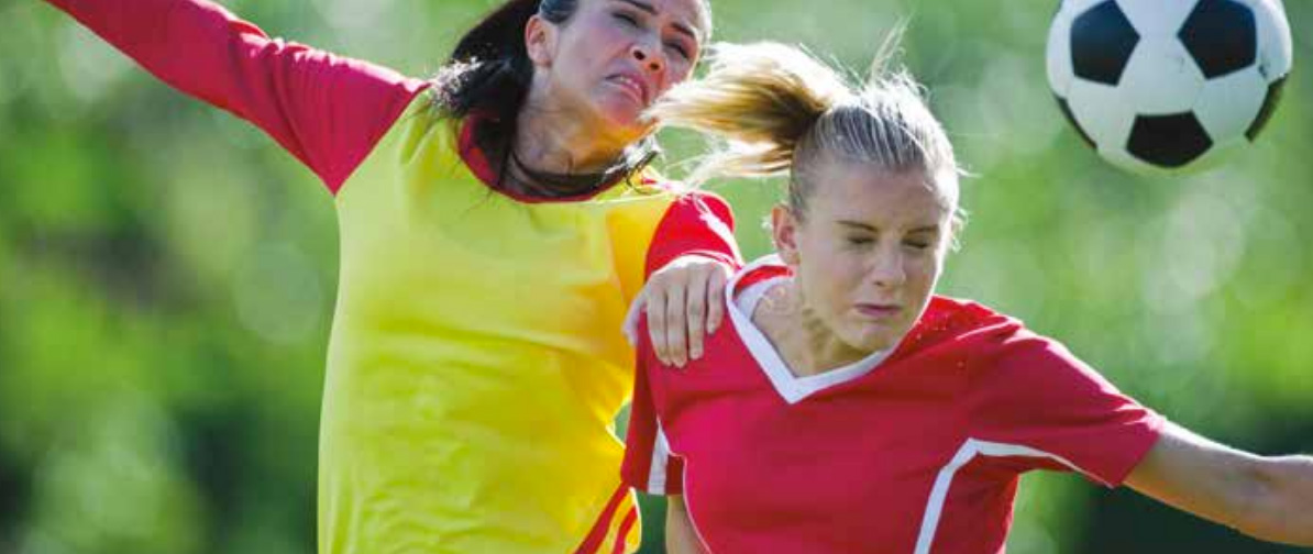 Two women going for a header in a soccer game