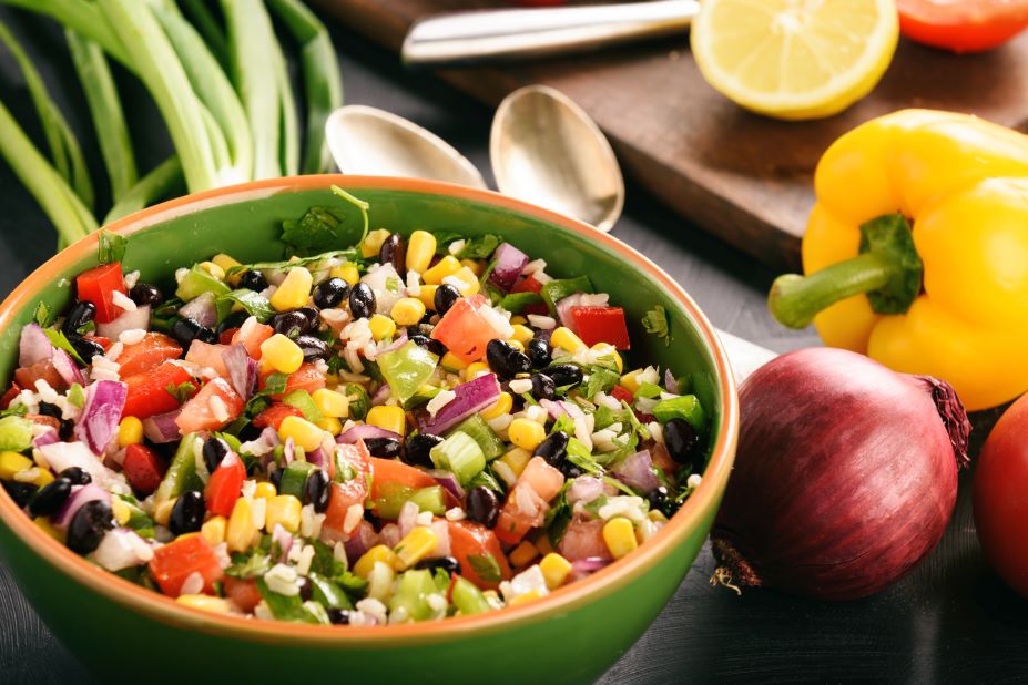 bowl of cowboy caviar with bell pepper and red onion beside bowl