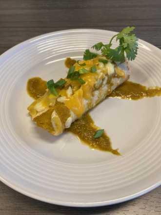 homemade tomatillo sauce over enchilada on plate