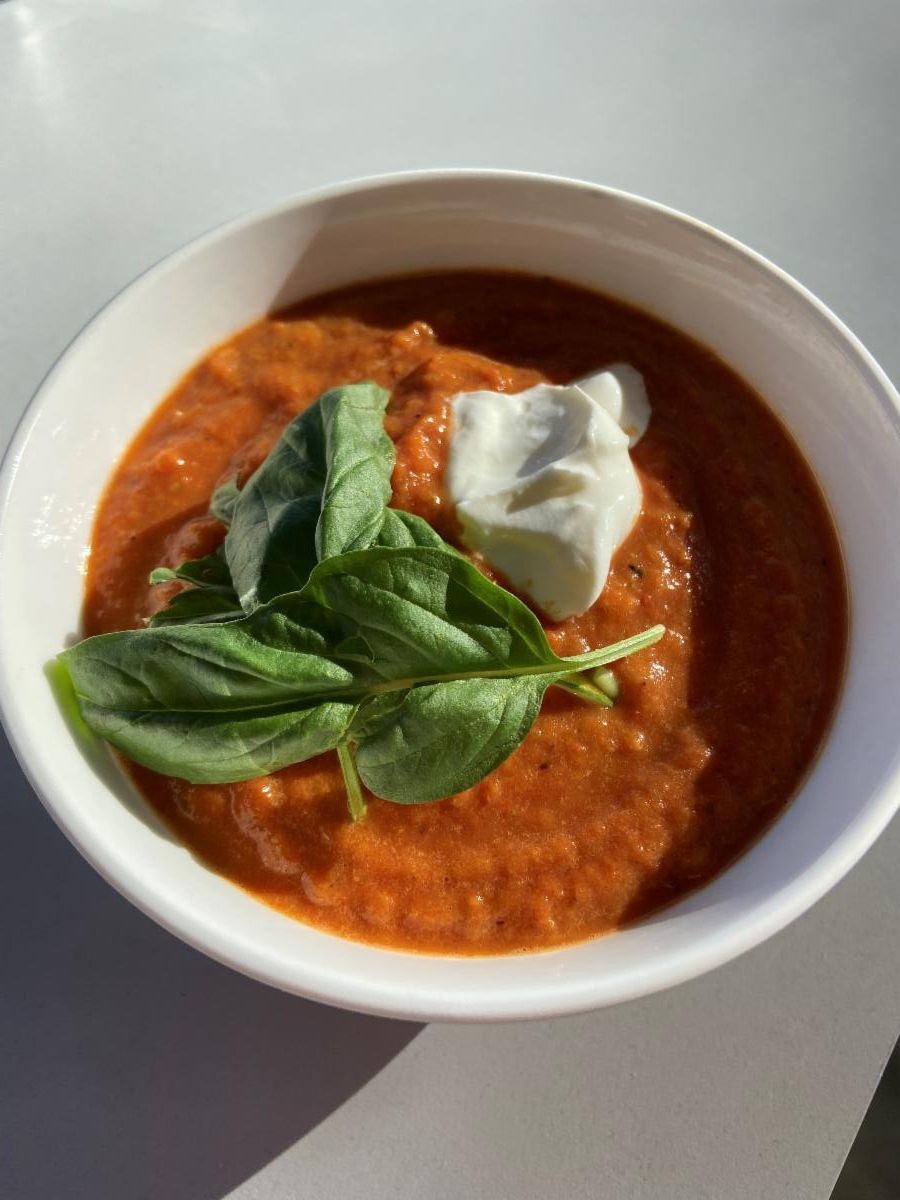 bowl of roasted red pepper and tomoto soup with fresh basil