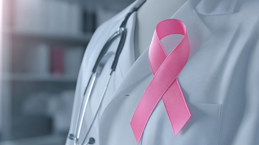 Pink ribbon on Doctor's white lab coat and stethoscope