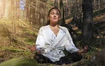 woman meditating in forest